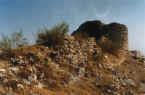 Restos de la muralla del sector este de la fortaleza. Al fondo, una torre circular esquinera. (C. Calvo Aguilar.)